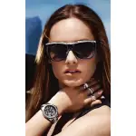 MICHAEL KORS MK5829-3 A person with long brown hair wears multiple rings and a stylish black watch while posing with a scenic background.